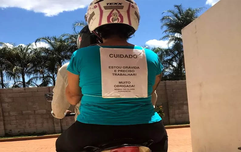 'Estou grÃ¡vida e preciso trabalhar' diz cartaz em mulher na garupa de moto em TrÃªs Lagoas